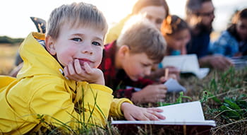 students write in notebooks on a field trip