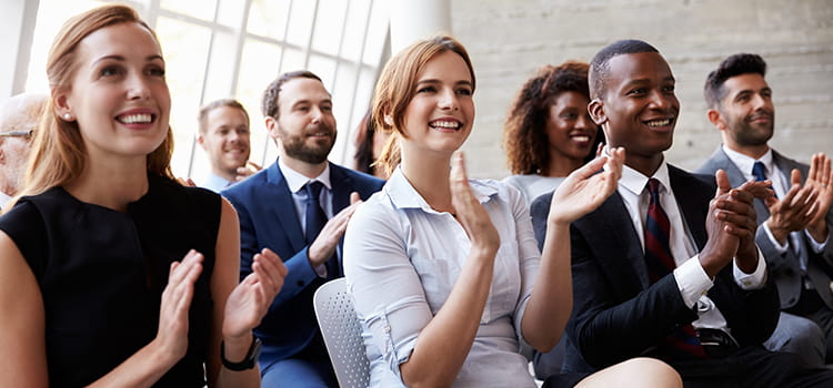 Conference attendees clap after a presentation